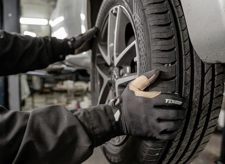 Mechaniker montiert Reifen an einem Fahrzeug in der Werkstatt
